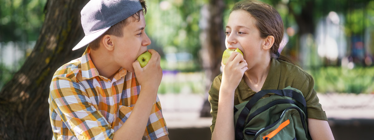 Zwei Freunde essen einen Apfel